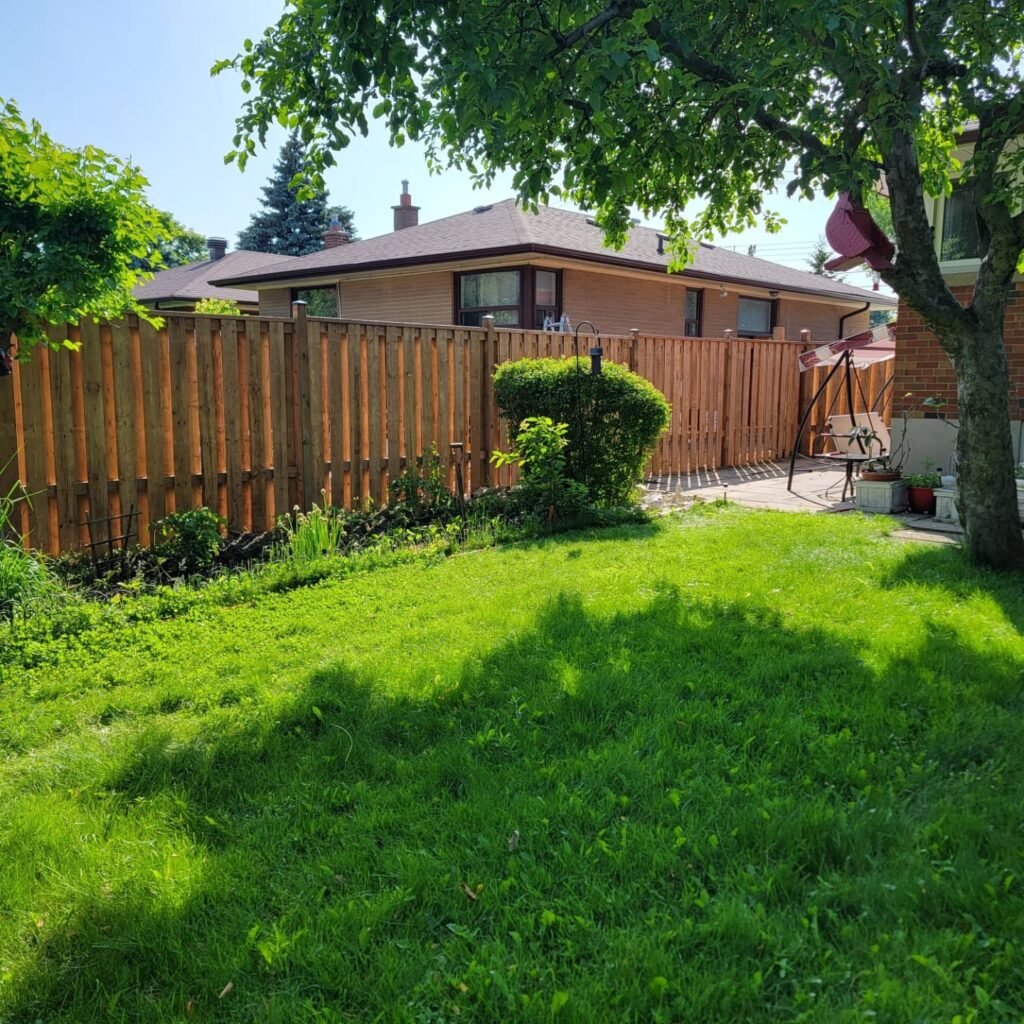 Paradise deck builders and fence installers backyard wood fence installation backyard with green grass in summer